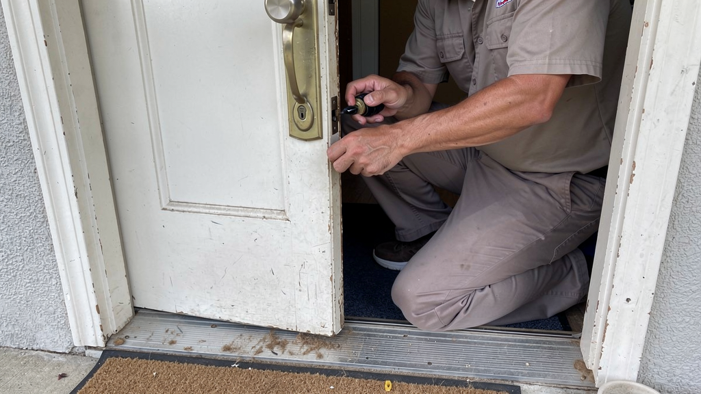 Locksmith using a non-destructive entry tool at a residential door